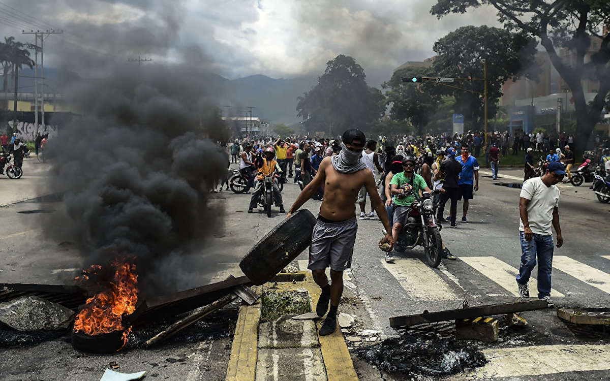Антиправительственные активисты строят баррикаду в городе Венесуэлы, Валенсия. 6 августа 2017